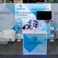 Caprion's 10x20 exhibit lives its brand of Enlightening Science with a 8x8 Lightwall. The halo lighting enhances the stand-off graphics and reception counter.